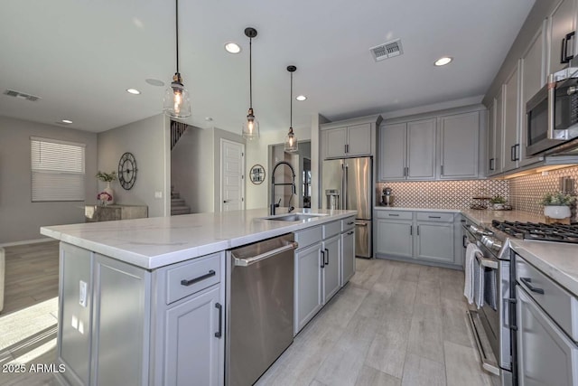 kitchen featuring stainless steel appliances, visible vents, a sink, and gray cabinetry