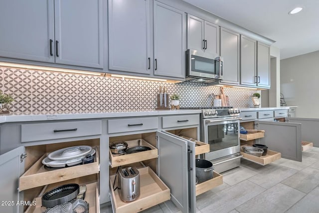 kitchen with appliances with stainless steel finishes, recessed lighting, light countertops, and decorative backsplash