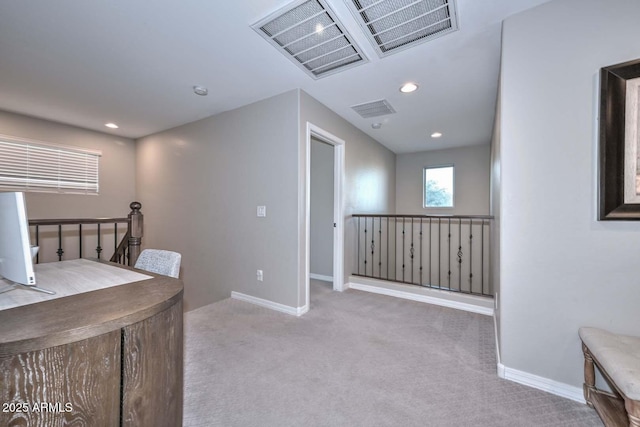 interior space with carpet, baseboards, visible vents, and an upstairs landing