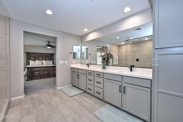 ensuite bathroom featuring double vanity, visible vents, ensuite bathroom, a sink, and tiled shower