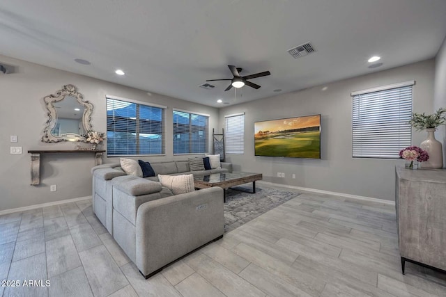 living area with light wood-style floors, recessed lighting, visible vents, and baseboards