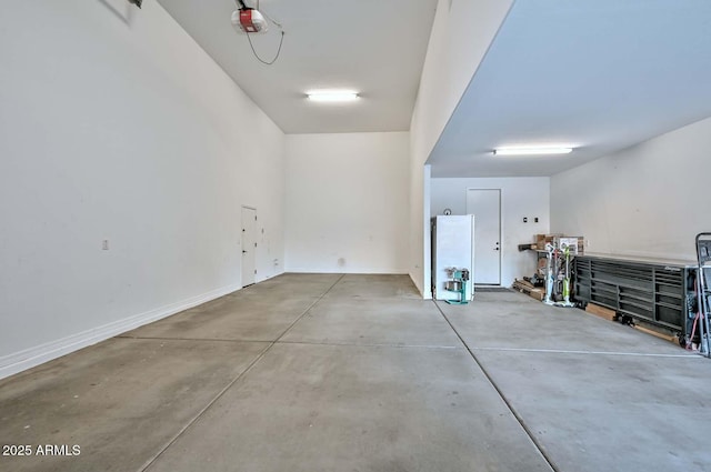 garage with a garage door opener and baseboards