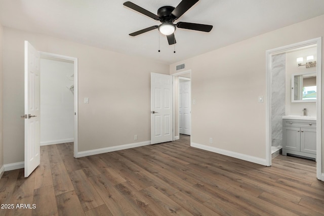 556 S Forest, Mesa, AZ 85204 - unfurnished bedroom featuring wood finished floors, a walk in closet, connected bathroom, and ceiling fan