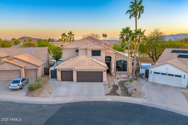 721 W Mountain Sky Ave, Phoenix, AZ 85045 - mediterranean / spanish-style home featuring a tile roof, concrete driveway, stucco siding, and an attached garage