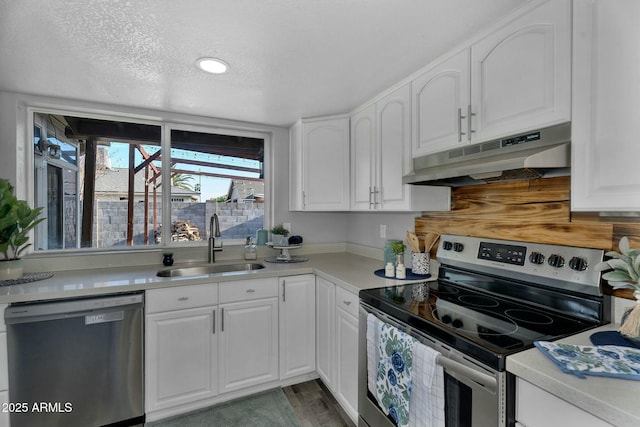 kitchen featuring light countertops, under cabinet range hood, stainless steel electric stove, a sink, and dishwasher