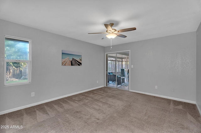 empty room with ceiling fan, baseboards, and carpet