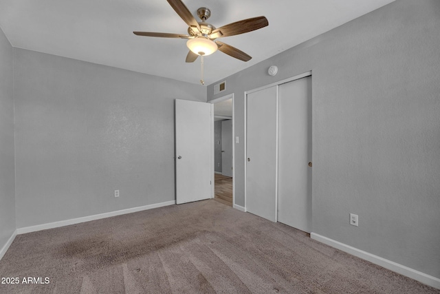 unfurnished bedroom with a ceiling fan, baseboards, carpet, and a closet
