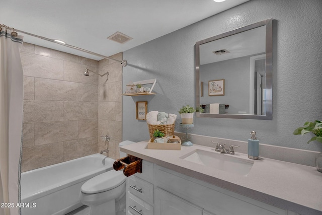 full bathroom featuring visible vents, vanity, a textured wall, shower / bathtub combination, and toilet