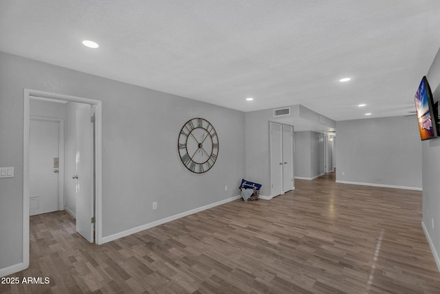 unfurnished room featuring recessed lighting, baseboards, visible vents, and wood finished floors