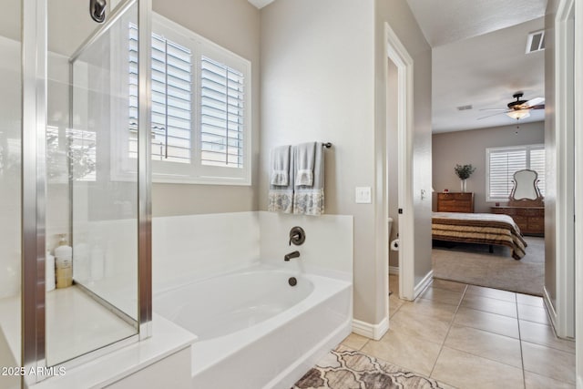 bathroom featuring a healthy amount of sunlight, ceiling fan, tile patterned floors, and a bathing tub