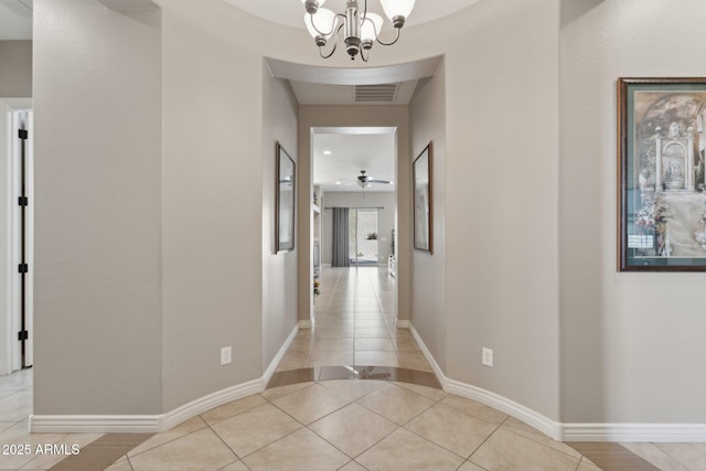 corridor featuring a chandelier and light tile patterned floors