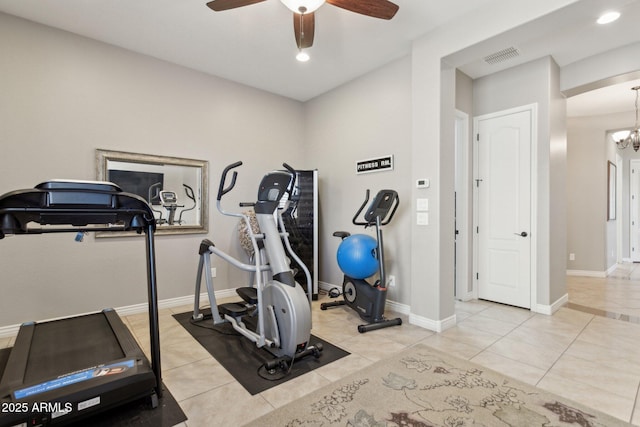 workout room with ceiling fan with notable chandelier and light tile patterned flooring