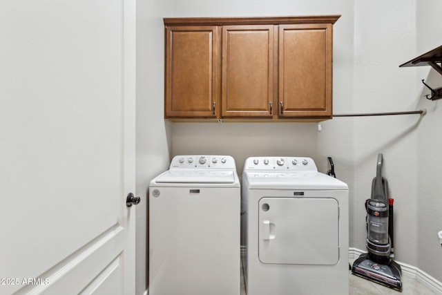 washroom featuring cabinets and washing machine and clothes dryer