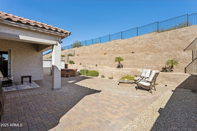 view of patio with a hot tub and an outdoor fire pit