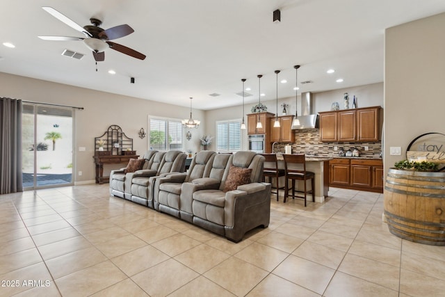 living room with ceiling fan with notable chandelier and light tile patterned floors