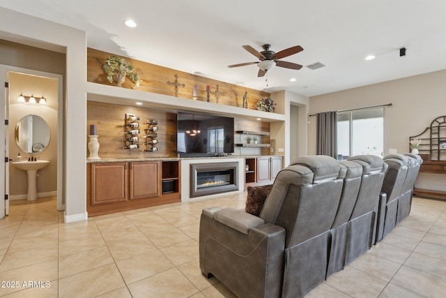 tiled living room featuring sink, ceiling fan, and built in features