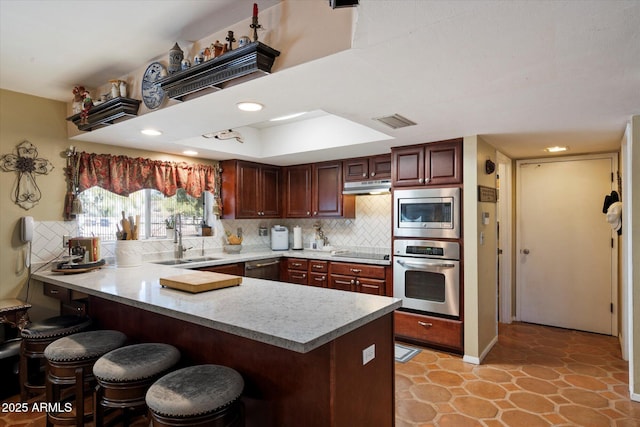 23265 S Via Del Arroyo, Queen Creek, AZ 85142 - kitchen featuring appliances with stainless steel finishes, a sink, under cabinet range hood, a peninsula, and a breakfast bar