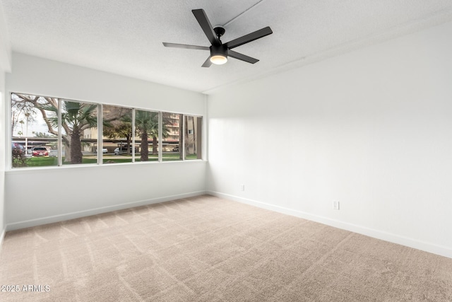 unfurnished room featuring ceiling fan, light colored carpet, and a textured ceiling