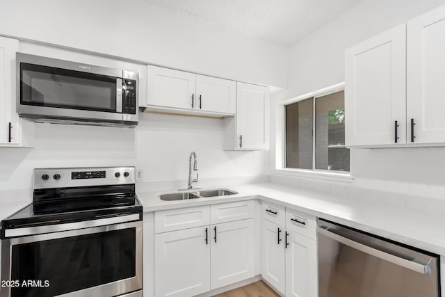 kitchen featuring appliances with stainless steel finishes, sink, and white cabinets