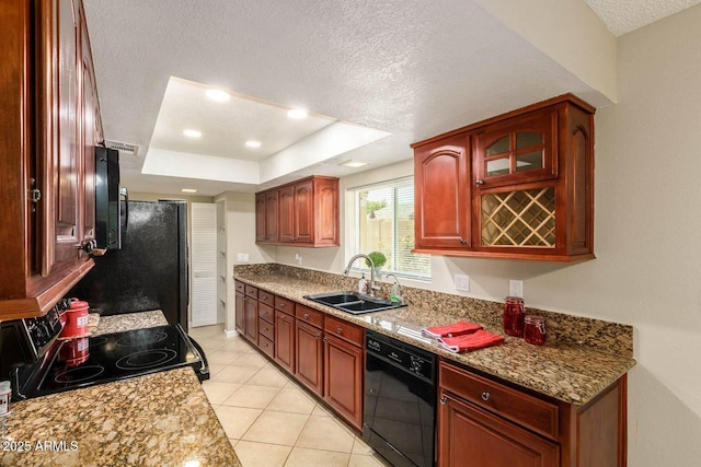kitchen with light tile patterned floors, a sink, a tray ceiling, a textured ceiling, and black appliances