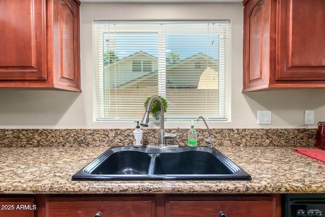 kitchen featuring dishwashing machine, a healthy amount of sunlight, and a sink