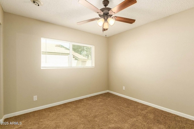 carpeted spare room with ceiling fan, a textured ceiling, and baseboards