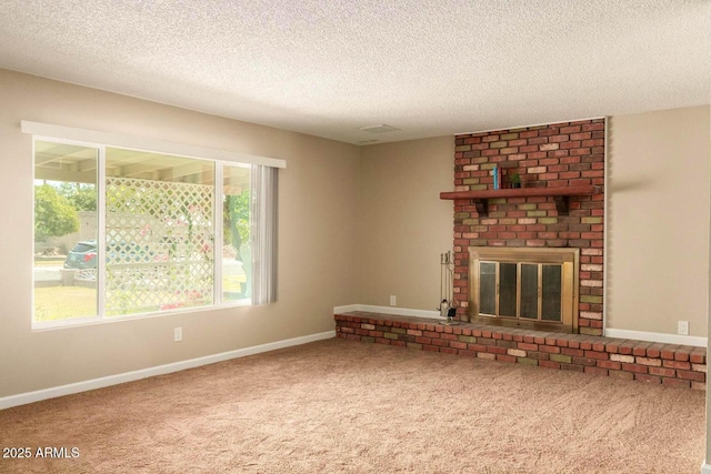 unfurnished living room with a textured ceiling, a brick fireplace, carpet floors, and baseboards