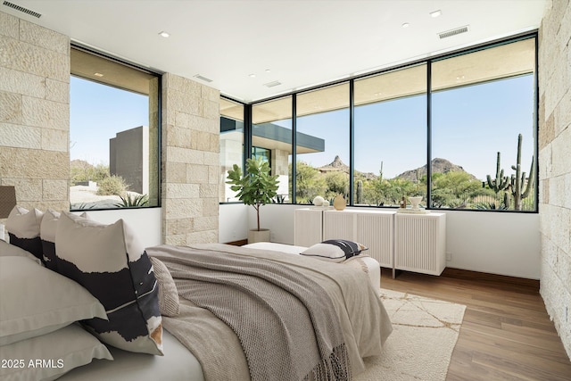 bedroom with radiator heating unit and light wood-type flooring