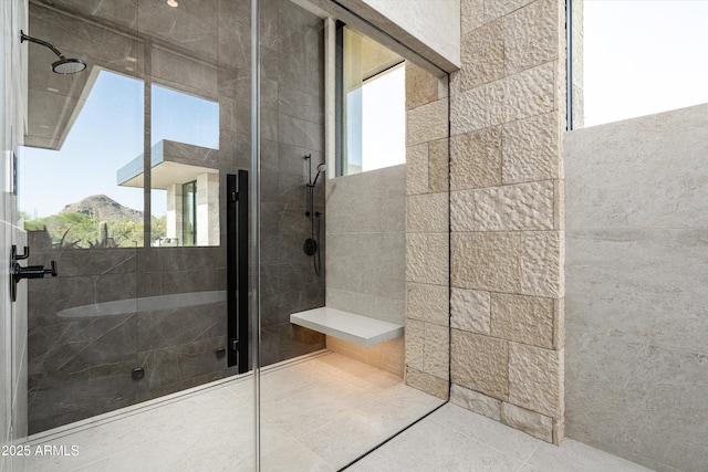 bathroom with a mountain view, tile patterned flooring, and a tile shower