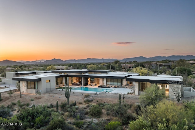 back house at dusk featuring a mountain view