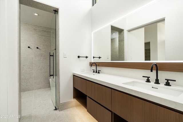 bathroom with vanity, a tile shower, and tile patterned floors