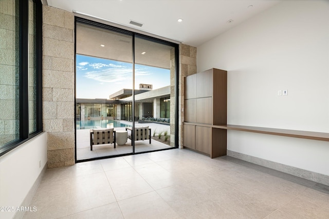 tiled spare room featuring floor to ceiling windows