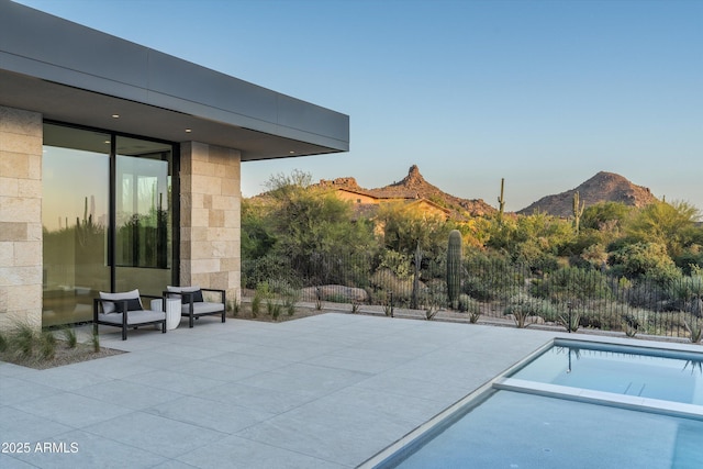 view of swimming pool featuring a mountain view and a patio