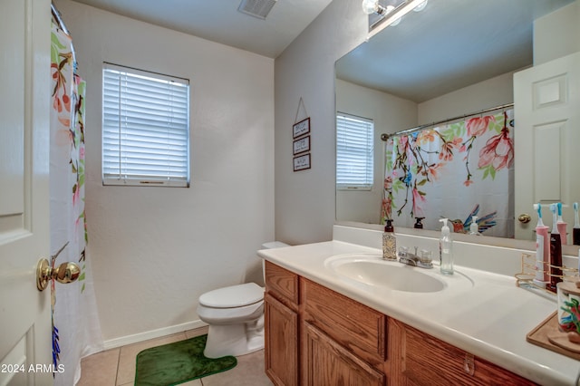 bathroom with vanity, toilet, a healthy amount of sunlight, and tile patterned flooring