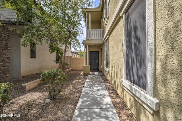 view of exterior entry with a balcony