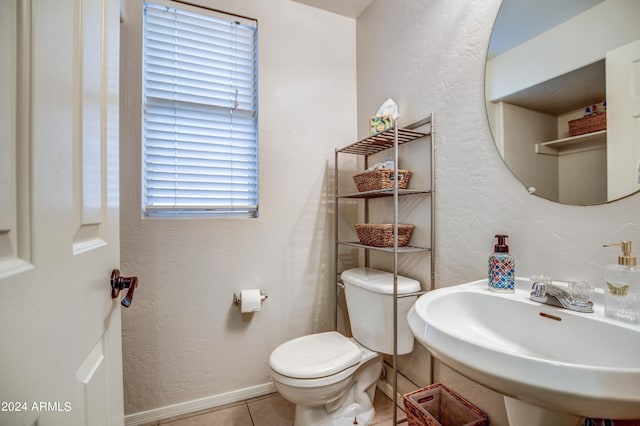 bathroom with plenty of natural light, sink, tile patterned flooring, and toilet