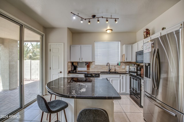 kitchen featuring plenty of natural light, a kitchen island, black appliances, and backsplash