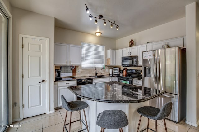 kitchen featuring white cabinetry, a center island, black appliances, and tasteful backsplash