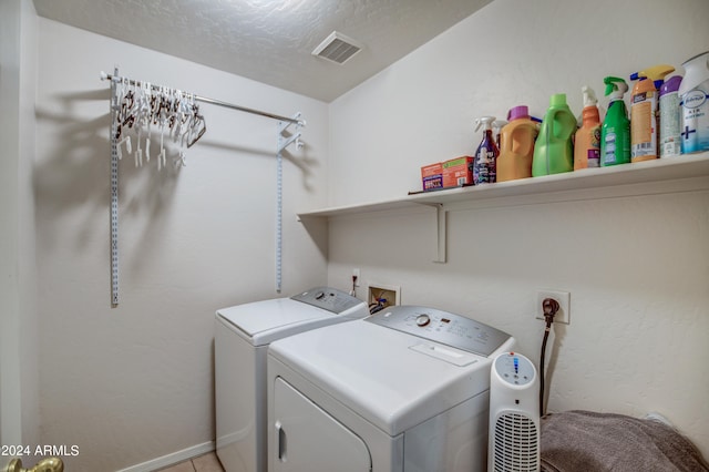 washroom with separate washer and dryer and a textured ceiling