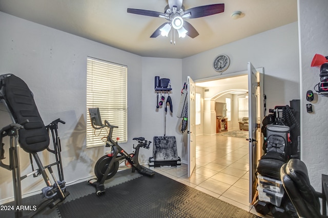 workout room with ceiling fan and light tile patterned floors