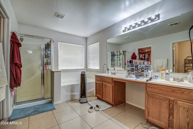 bathroom featuring tile patterned flooring, separate shower and tub, and dual vanity