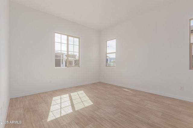 spare room featuring wood finished floors and baseboards