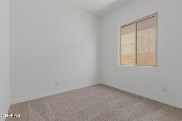 carpeted spare room featuring baseboards