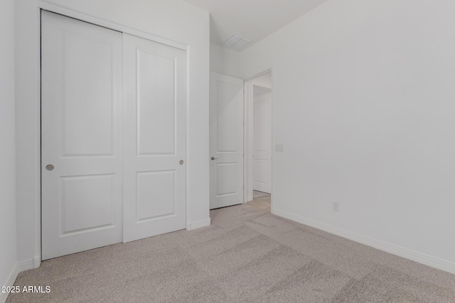 unfurnished bedroom with a closet, carpet flooring, and baseboards