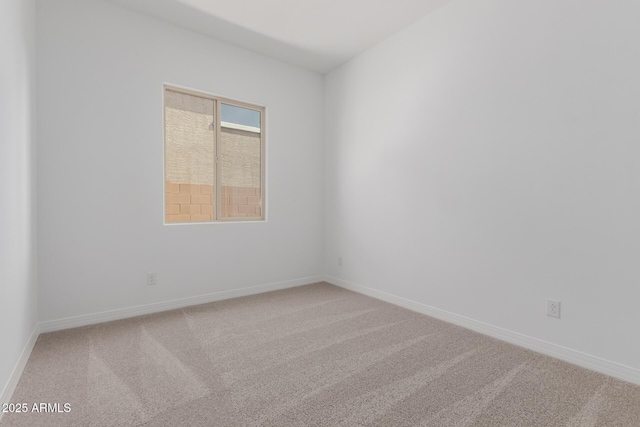 carpeted empty room featuring baseboards