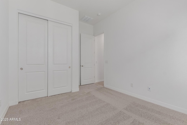 unfurnished bedroom featuring a closet, carpet, visible vents, and baseboards