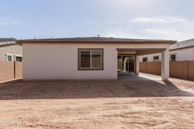 rear view of house with a patio, a fenced backyard, and stucco siding