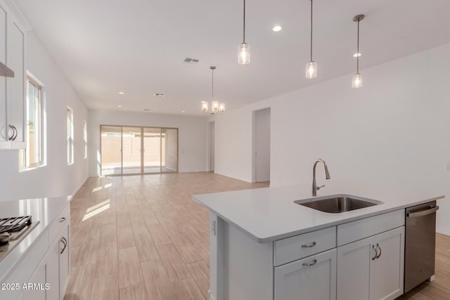 kitchen with a sink, visible vents, light countertops, appliances with stainless steel finishes, and light wood-type flooring