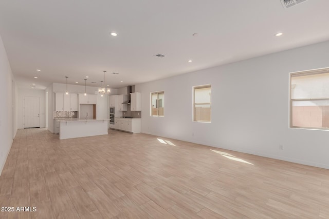 unfurnished living room with recessed lighting, visible vents, and light wood-style floors