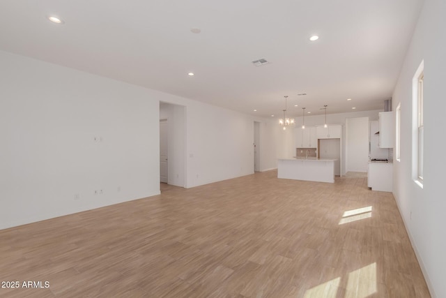 unfurnished living room with recessed lighting, visible vents, and light wood-style flooring